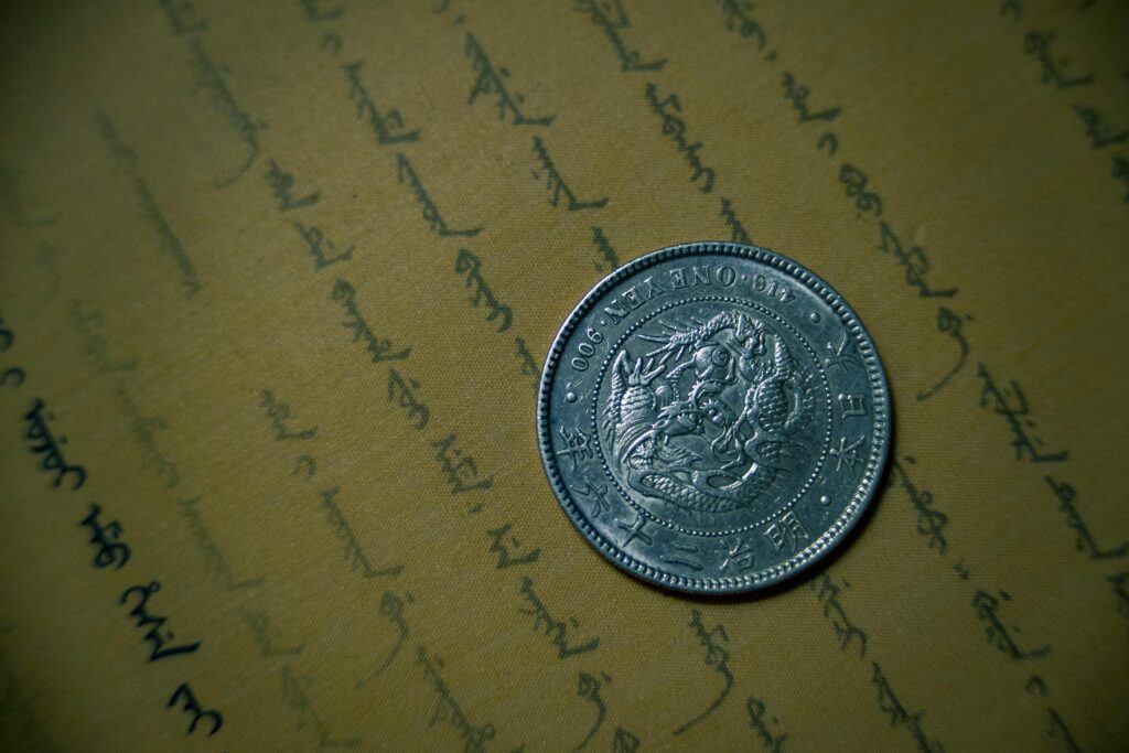Close-up of an antique silver coin resting on vintage handwritten document.